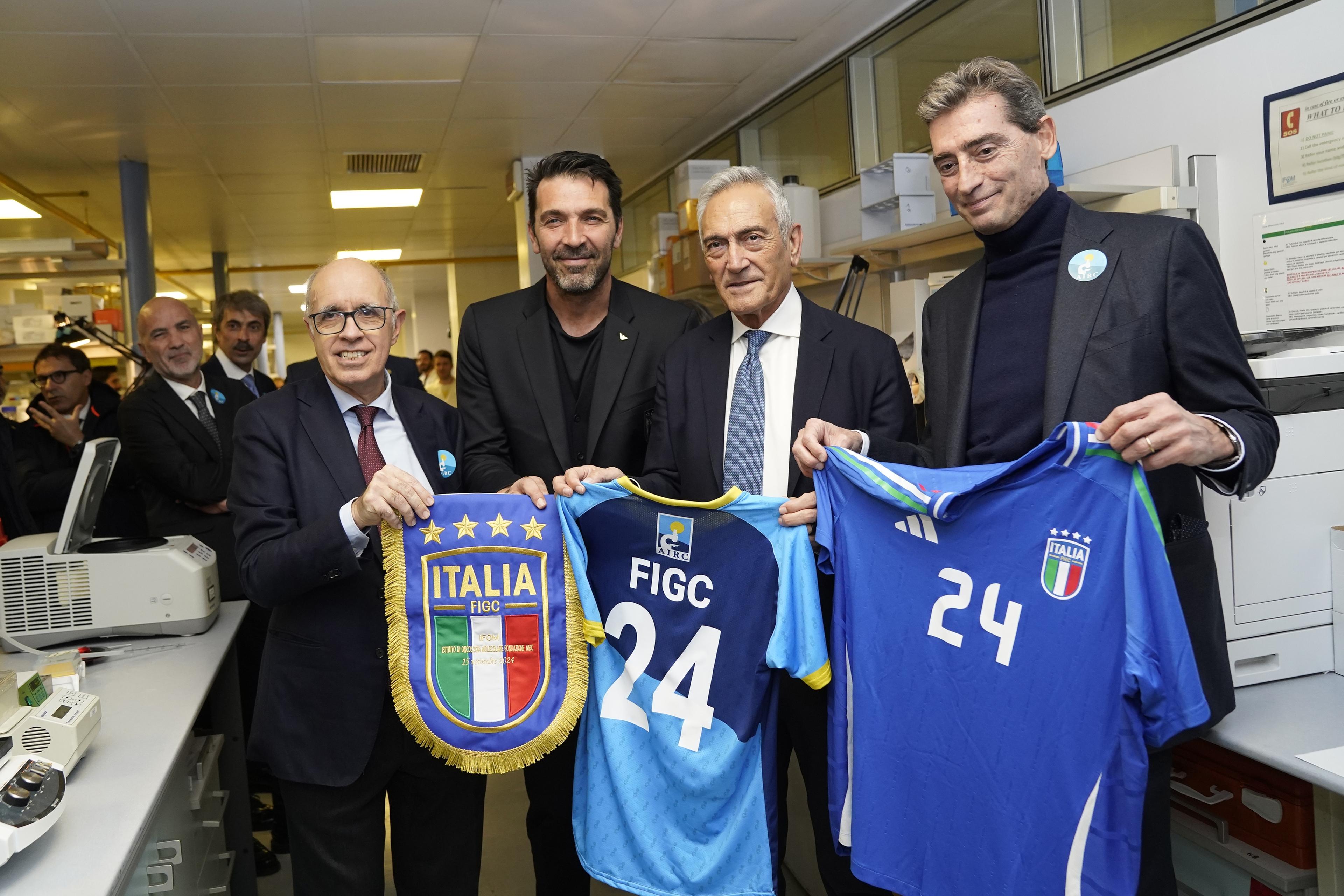 MILAN, ITALY - NOVEMBER 15: Giovanni Azzone President of IFOM, Gianluigi Buffon of FIGC, Gabriele Gravina President of FIGC and Andrea Sironi President of AIRC pose for a photo during the visit of FIGC delegation at the IFOM Cancer Reseatch Institute on November 15, 2024 in Milan, Italy. (Photo by FIGC/FIGC via Getty Images)