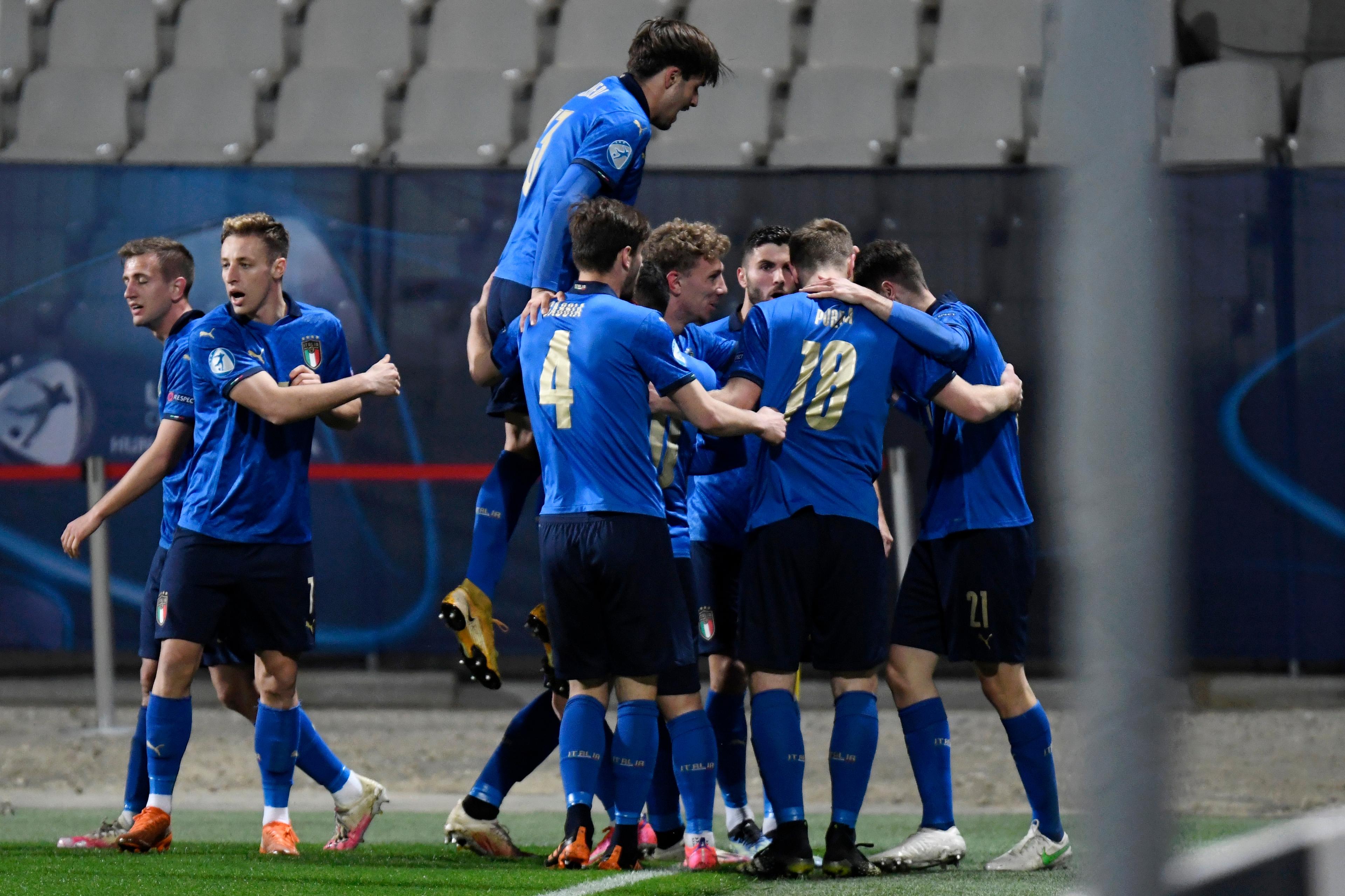 CELJE, SLOVENIA - MARCH 30: Giulio Maggiore (Hidden) of Italy celebrates with team mates after scoring their side\\'s first goal during the 2021 UEFA European Under-21 Championship Group B match between Italy and Slovenia at Stadion Celje on March 30, 2021 in Celje, Slovenia. Sporting stadiums around Slovenia remain under strict restrictions due to the Coronavirus Pandemic as Government social distancing laws prohibit fans inside venues resulting in games being played behind closed doors. (Photo by Jurij Kodrun/Getty Images)
