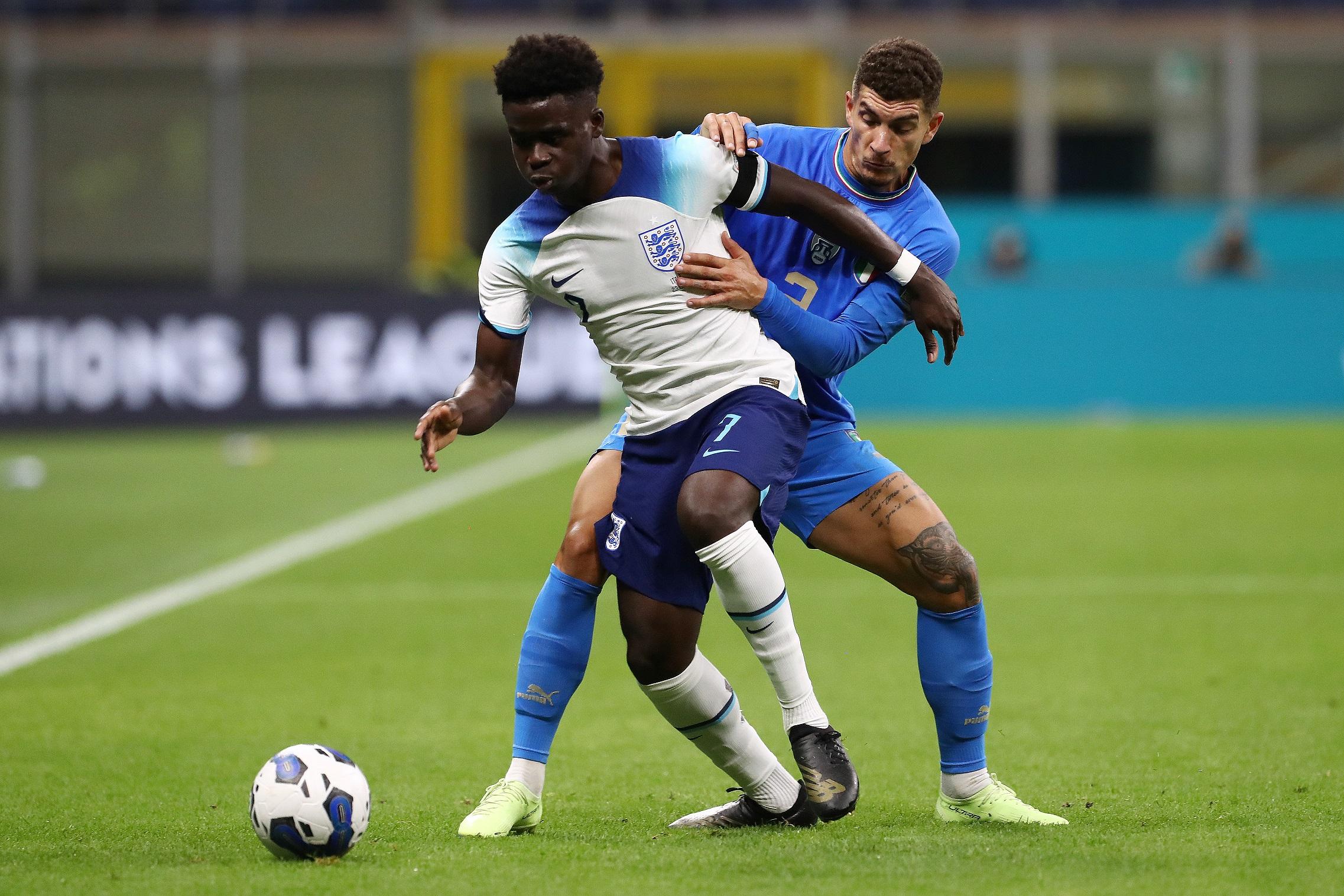 MILAN, ITALY - SEPTEMBER 23: Bukayo Saka of England battles for possession with Giovanni Di Lorenzo of Italy during the UEFA Nations League League A Group 3 match between Italy and England at San Siro on September 23, 2022 in Milan, Italy. (Photo by Marco Luzzani/Getty Images)