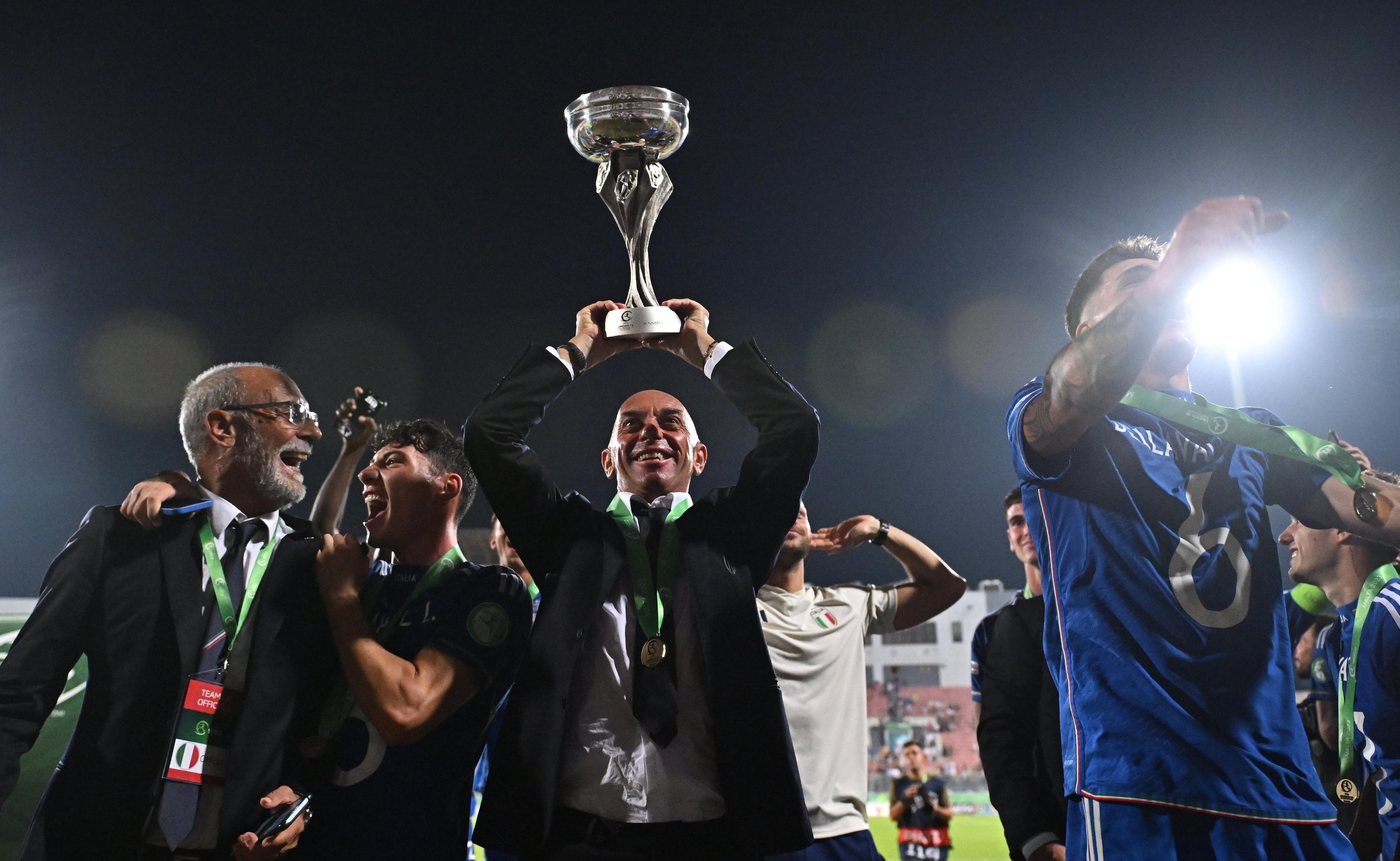 TA' QALI, MALTA - JULY 16: Italy head coach Alberto Bollini celebrates with the trophy after the UEFA European Under-19 Championship 2022/23 final match between Portugal and Italy at the National Stadium on July 16, 2023 in Ta' Qali, Malta. (Photo by Seb Daly - Sportsfile/UEFA via Getty Images)