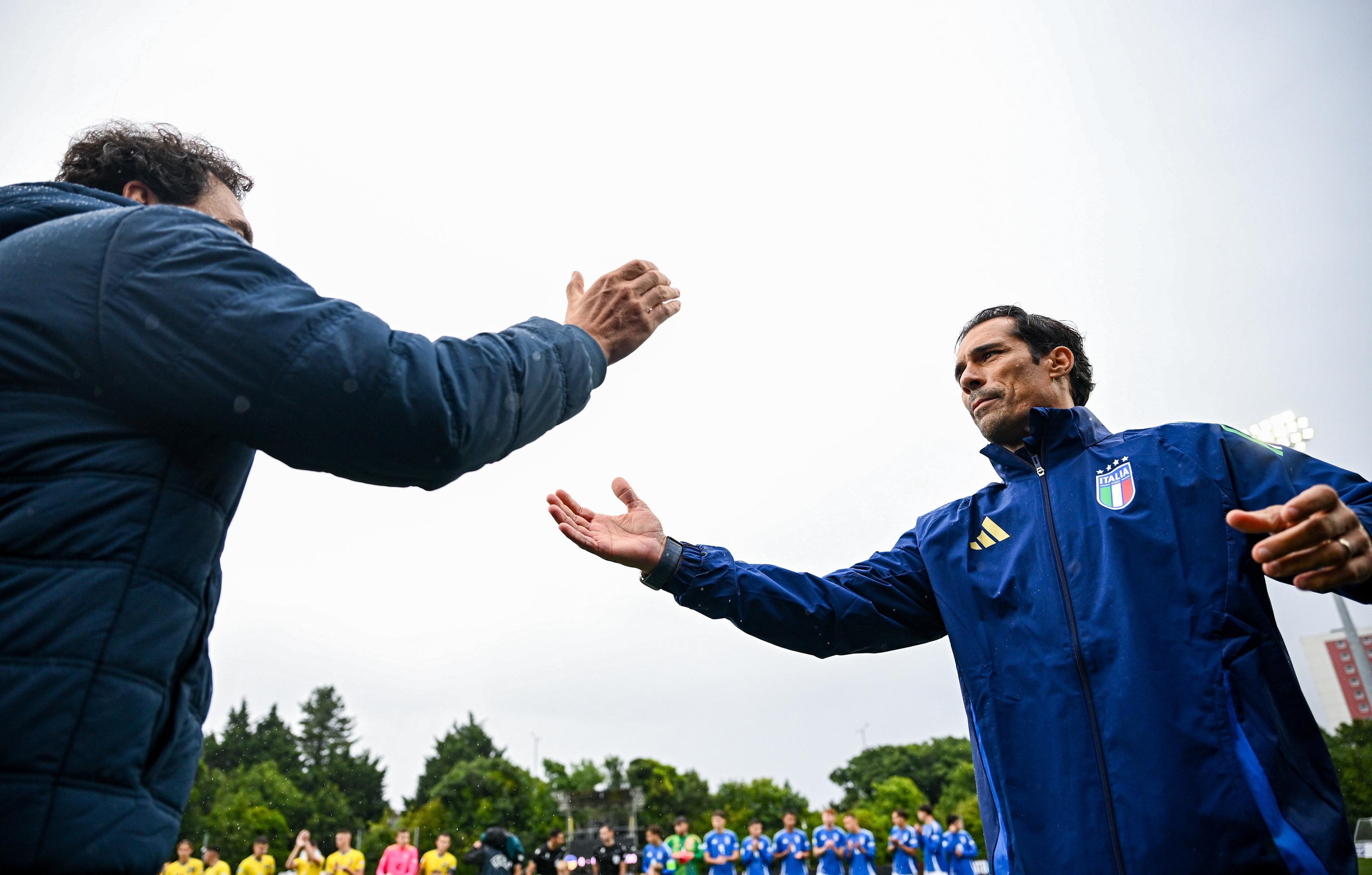 LARNE, NORTHERN IRELAND - JULY 21: Italy manager Bernardo Corradi, right, shakes hands with Ukraine manager Dmytro Mikhailenko before the UEFA European Under-19 Championship 2024 Group A match between Ukraine and Italy at Inver Park on July 21, 2024 in Larne, Northern Ireland. (Photo by Ramsey Cardy - Sportsfile/UEFA via Getty Images)
