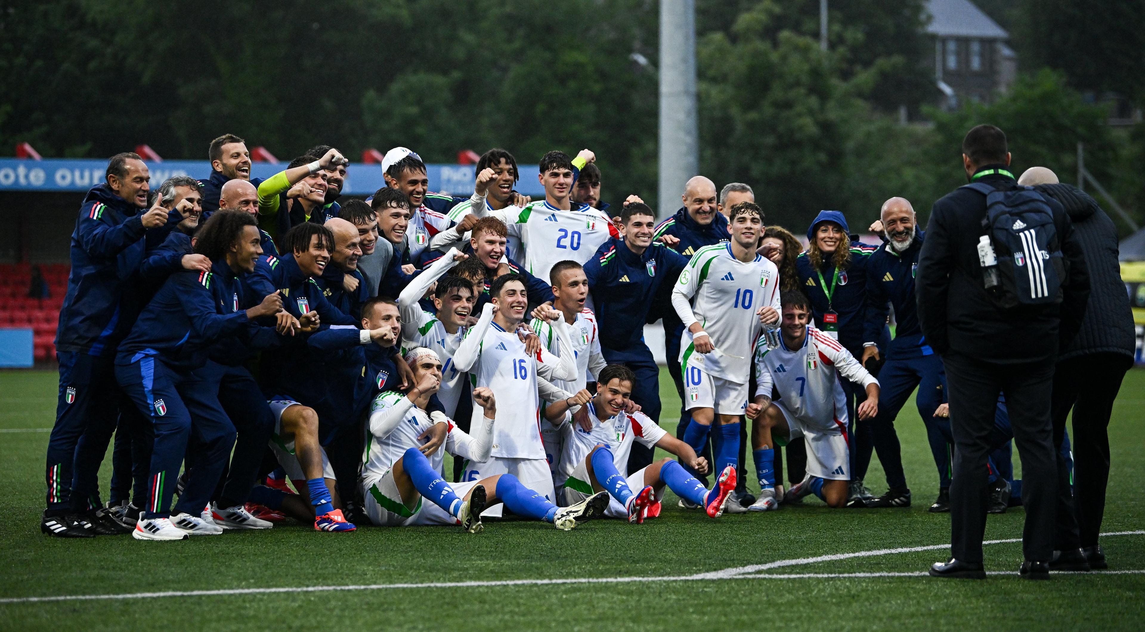 LARNE, NORTHERN IRELAND - JULY 18: Italy players and staff celebrate after their side's victory in the UEFA European Under-19 Championship 2024 Group A match between Northern Ireland and Italy at Inver Park on July 18, 2024 in Larne, Northern Ireland. (Photo by Seb Daly - Sportsfile/UEFA via Getty Images)