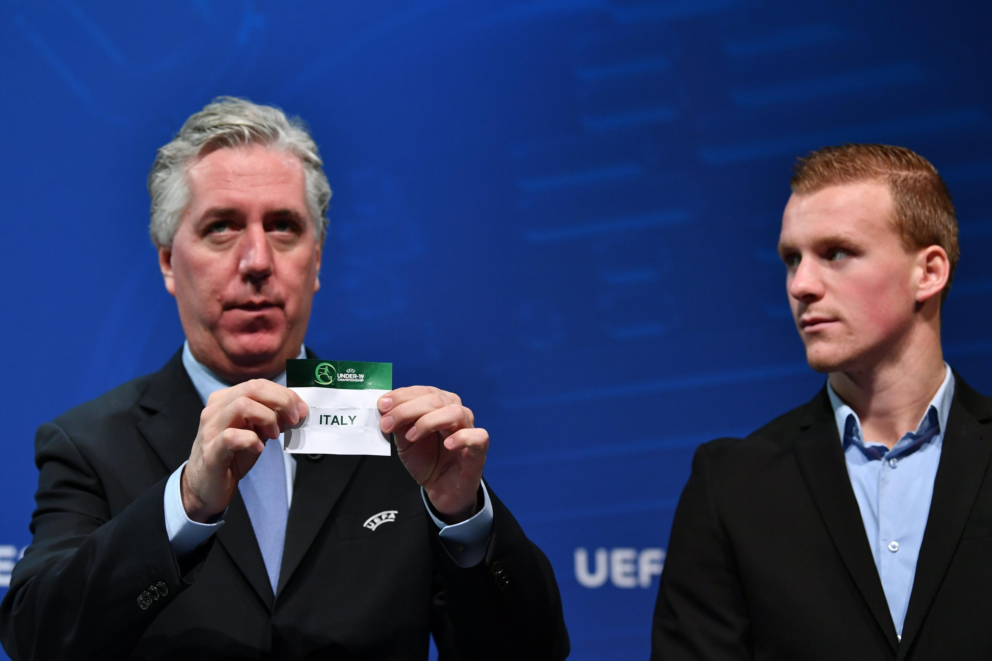 NYON, SWITZERLAND - DECEMBER 6: Chairman of the UEFA Youth and Amateur Football Committee John Delaney, in the company of Netherlands Under-19 player Dani De Wit (R), draws out the name of Italy during the UEFA European Under-19 Championship 2017/18 Elite Round draw at the UEFA headquarters, The House of European Football on December 6, 2017 in Nyon, Switzerland. (Photo by Harold Cunningham - UEFA/UEFA via Getty Images)