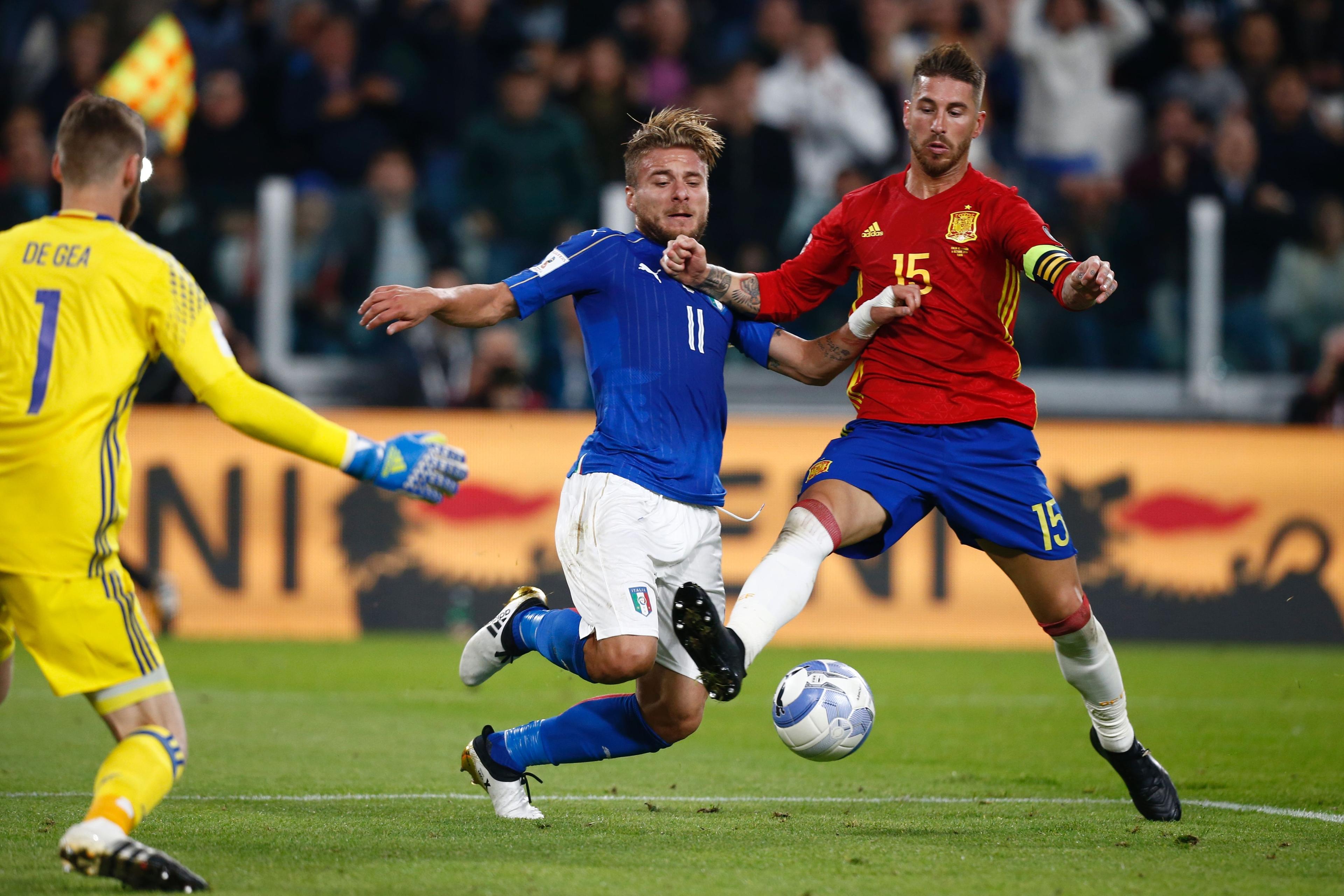 Italy\\'s forward Ciro Immobile (C) fights for the ball with Spain\\'s defender Sergio Ramos (R) in front of Spain\\'s goalkeeper David de Gea during the WC 2018 football qualification match between Italy and Spain on October 6, 2016 at the Juventus stadium in Turin. The match ended on a 1-1 draw. / AFP / Marco BERTORELLO        (Photo credit should read MARCO BERTORELLO/AFP/Getty Images)