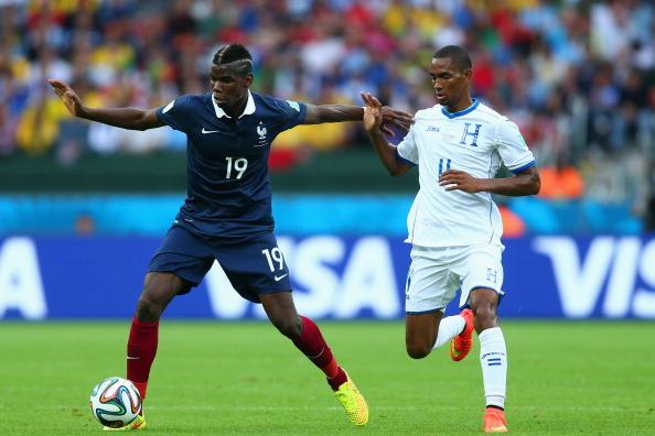 PORTO ALEGRE, BRAZIL - JUNE 15: Paul Pogba of France holds off a challenge by Jerry Bengtson of Honduras during the 2014 FIFA World Cup Brazil Group E match between France and Honduras at Estadio Beira-Rio on June 15, 2014 in Porto Alegre, Brazil. (Photo by Jeff Gross/Getty Images)