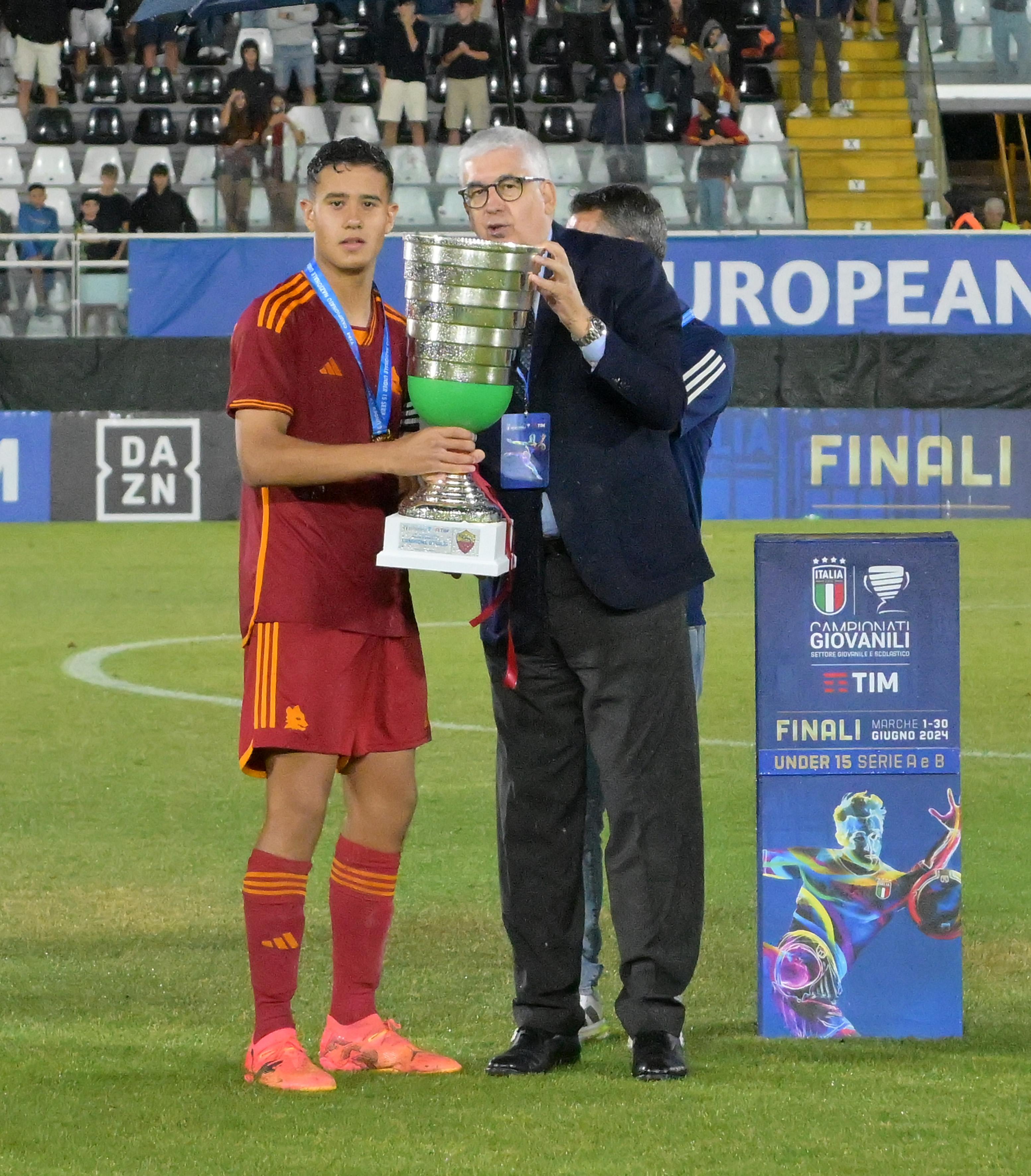 ASCOLI PICENO, ITALY - JUNE 25: Vito Roberto Tisci President of the Youth and School Sector of the FIGC awards, and Giampaolo Bonifazi of as captain of Team AS Roma after the U15 Serie A e B Final match between AS Roma and Genoa at Stadio Cino e Lillo Del Duca on June 25, 2024 in Ascoli Piceno, Italy. (Photo by Giuseppe Bellini/Getty Images)
