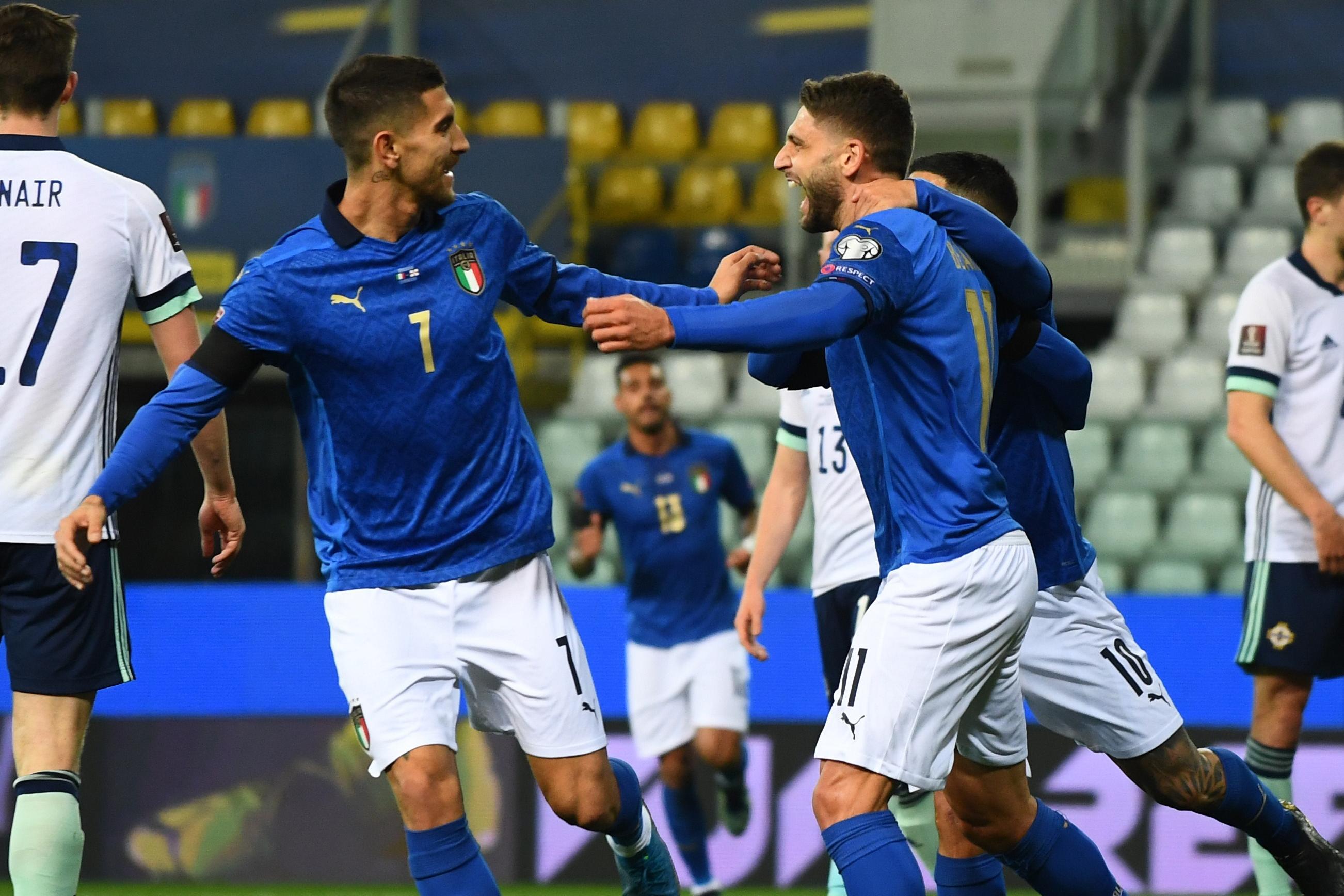 PARMA, ITALY - MARCH 25:  Domenico Berardi of Italy celebrates with Lorenzo Pellegrini after scoring the opening goal during the FIFA World Cup 2022 Qatar qualifying match between Italy and Northern Ireland on March 25, 2021 in Parma, Italy. Sporting stadiums around Italy remain under strict restrictions due to the Coronavirus Pandemic as Government social distancing laws prohibit fans inside venues resulting in games being played behind closed doors. (Photo by Claudio Villa/Getty Images)