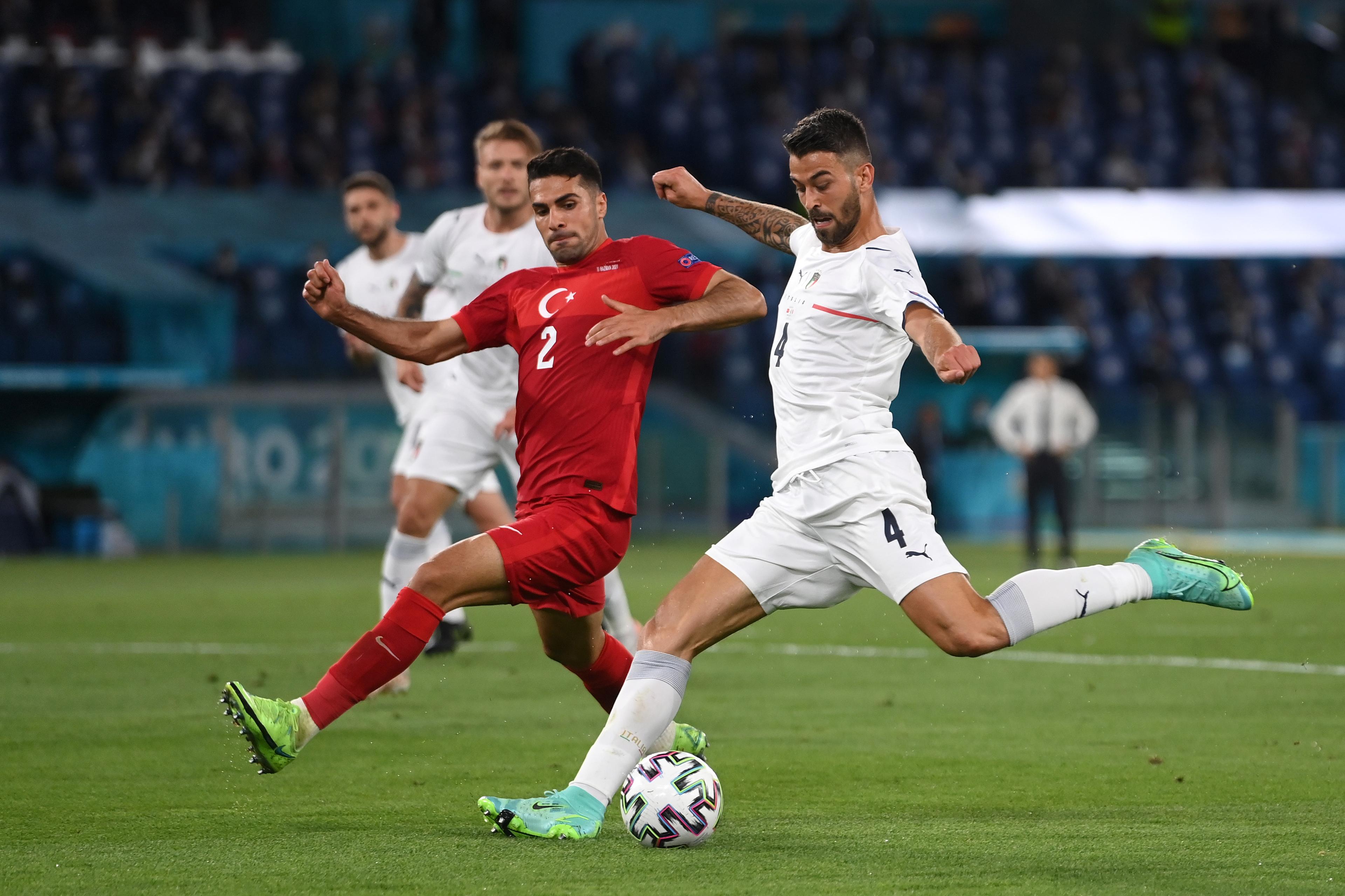 ROME, ITALY - JUNE 11: Leonardo Spinazzola of Italy shoots whilst under pressure from Zeki Celik of Turkey during the UEFA Euro 2020 Championship Group A match between Turkey and Italy at the Stadio Olimpico on June 11, 2021 in Rome, Italy. (Photo by Mike Hewitt/Getty Images)