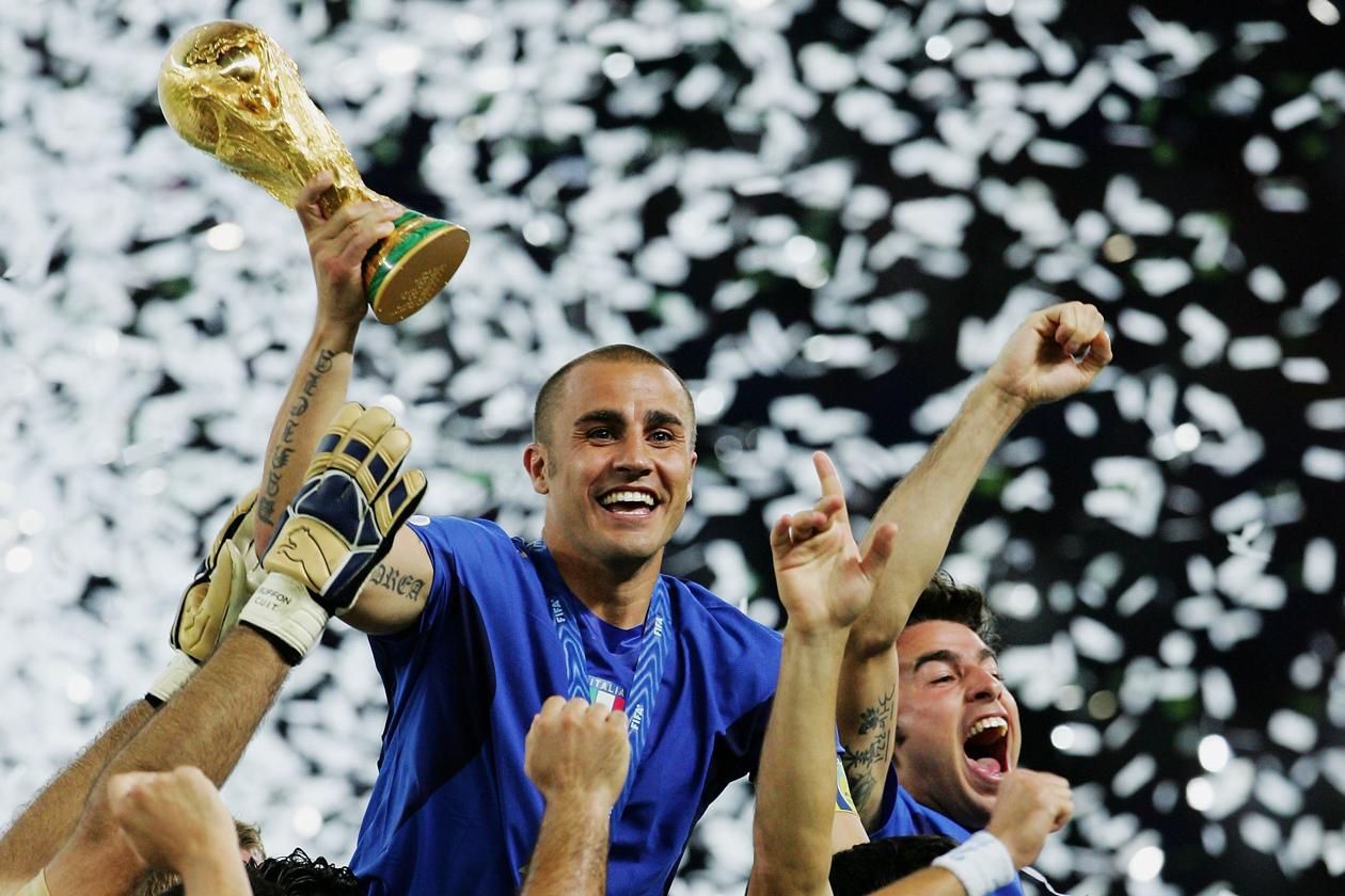 BERLIN - JULY 09: The Italian players celebrate as Fabio Cannavaro of Italy lifts the World Cup trophy aloft following victory in a penalty shootout at the end of the FIFA World Cup Germany 2006 Final match between Italy and France at the Olympic Stadium on July 9, 2006 in Berlin, Germany. (Photo by Alex Livesey/Getty Images)