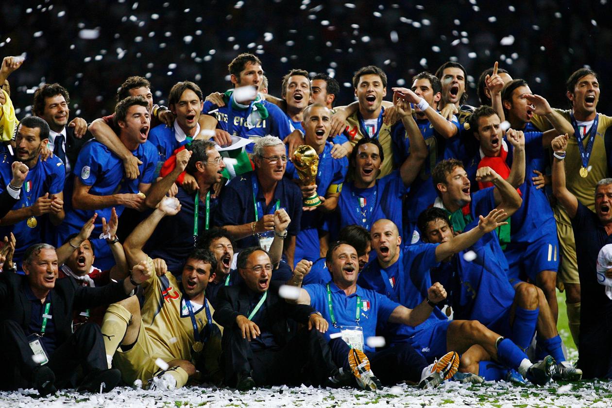 BERLIN - JULY 09:  The Italian players and coaching staff celebrate with the World Cup trophy following their victory in a penalty shootout at the end of the FIFA World Cup Germany 2006 Final match between Italy and France at the Olympic Stadium on July 9, 2006 in Berlin, Germany.  (Photo by Shaun Botterill/Getty Images)