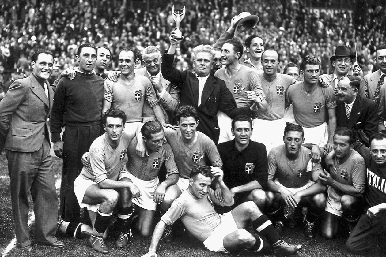 Italy\\'s national soccer team poses with the World Cup trophy after beating Hungary 4-2 in the World Cup final, 19 June 1938 in Colombes, in the suburbs of Paris.(Standing from L : Amadeo Biavati (4th L), coach Vittorio Pozzo holding the trophy, Silvio Piola, Giovanni Ferrari, Gino Colaussi; first row, from L : Ugo Locatelli, Giuseppe Meazza, Alfredo Foni, Pietro Serantoni, Aldo Olivieri, Pietro Rava and Michele Andreolo) (Photo credit should read STAFF/AFP/Getty Images)